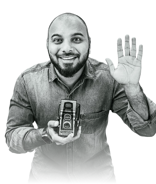 Jatin Jain holding a vintage camera and waving